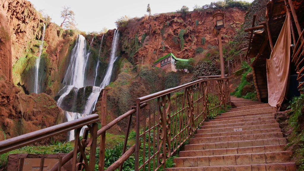Ouzoud Waterfall framed by olive trees and rocks.